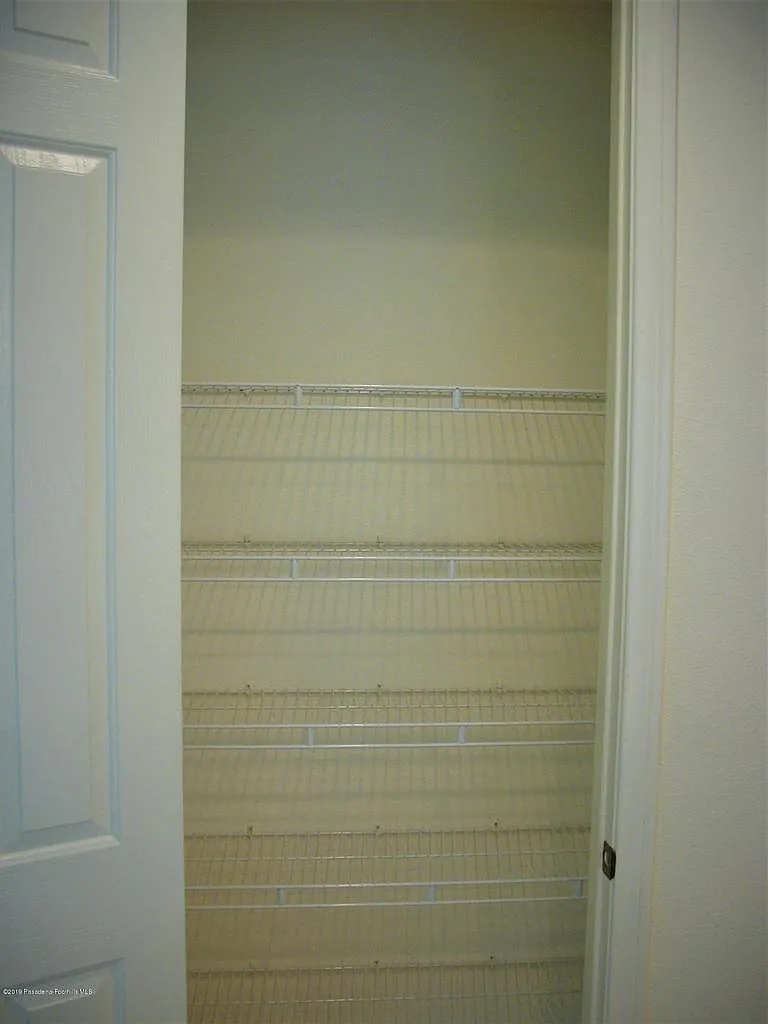 Empty white pantry with metal wire shelves, clean and minimalist