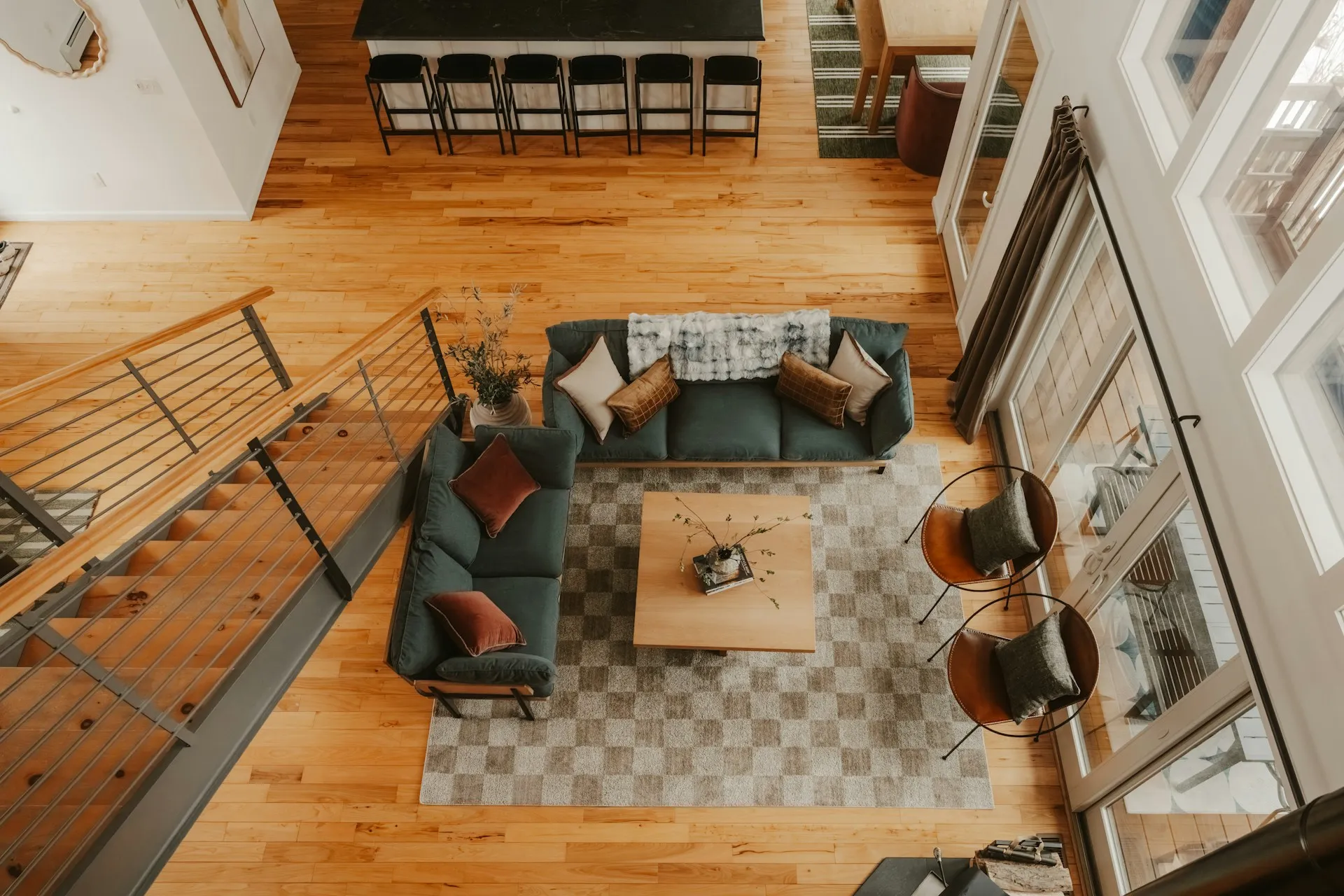 View of a living room with a green sofa and a center table and two chairs with a gray carpet.